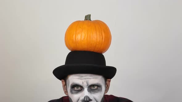 A Terrible Man in Clown Makeup and with a Pumpkin on His Head Threatens His Victim with a Knife. A
