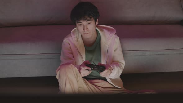 Young Asian Man Playing Video Game alt
