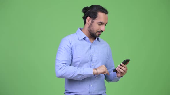 Young Bearded Indian Businessman Using Phone and Looking Surprised alt