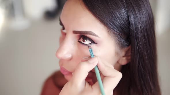 High Angle Footage of Unrecognizable Make Up Artist Applying and Blending Model's Lower Eyelid with alt