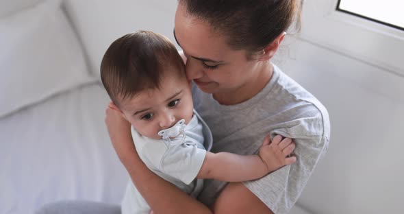 Young loving mother having tender moment with her baby at home