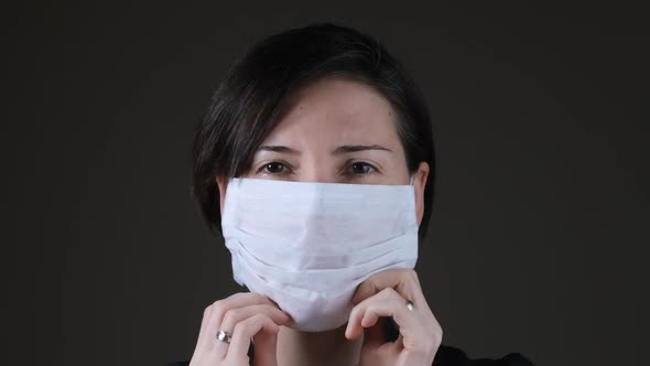 Portrait of a Caucasian woman wearing a white medical mask for protection