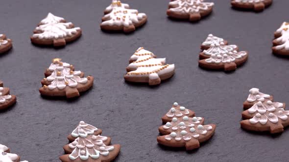 Side View of Rotating Gingerbread Cookies Christmas Trees on Slate Table