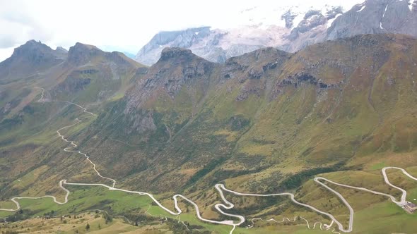 A long winding mountain road in the Dolomites of northern Italy, Aerial drone tilt-down reveal shot alt