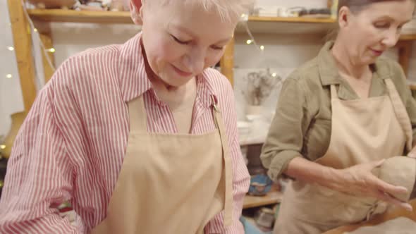 Two Senior Female Crafters Making Clay Bowls in Ceramics Workshop alt