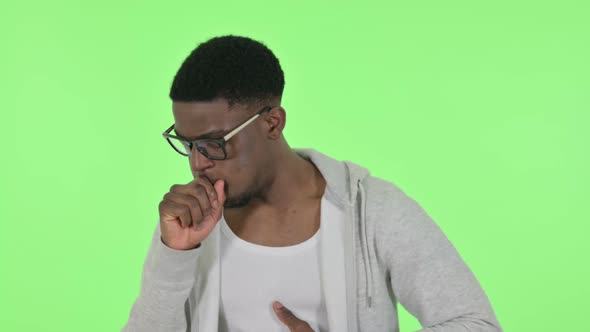 African Man Coughing on Green Background alt