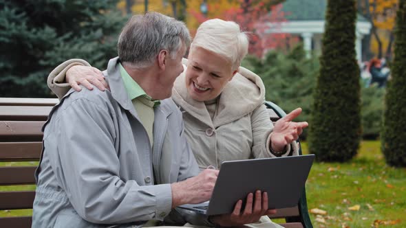 Happy Grandparents Couple Family Resting with Computer in Park Middle Aged Woman Senior Man Hold alt