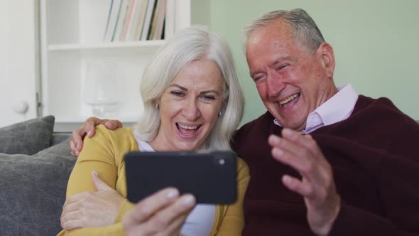 Happy senior caucasian couple making video call using laptop computer alt