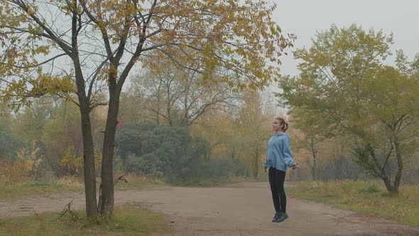 Woman Jumping Rope on Foggy Autumn Morning alt