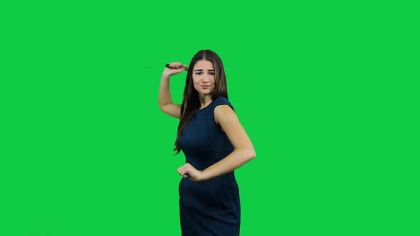 Girl discourages and threaten with telescopic bat in front of a green screen alt