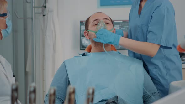 Patient with Oxygen Mask Receiving Anesthesic in Dentistry Cabinet alt