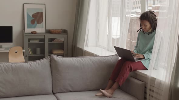 Beautiful African Woman Using Laptop at Home alt