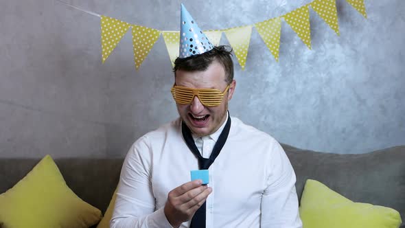 Funny Man Opens His Birthday Present And Screams With Joy.Young Very Cheerful And Happy Man Birthday