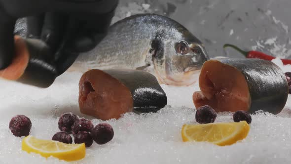 A Blackgloved Merchant's Hand Places Salmon Steaks on a Snowy Display Case alt