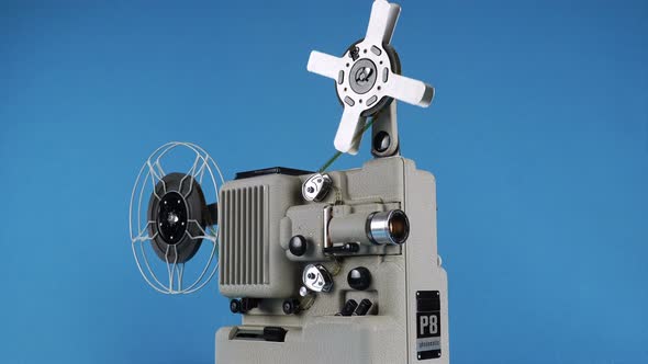 Rotating Vintage Movie Projector On A Blue Background. 