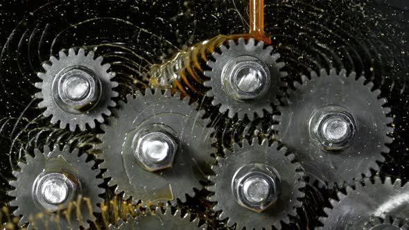 Super Slow Motion Shot of Gear Mechanism and Oil on Dark Background at 1000 Fps alt