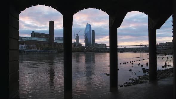 Tate Modern and London city skyline at sunset on the River Thames beach at low tide by Millennium Br alt