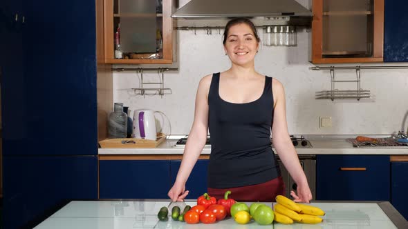 Girl Shows Thumb Up Standing Near Fresh Vegetables and Fruit alt