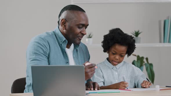 Mature African American Grandfather Helps Granddaughter with Homework Little Girl Surprised Draws alt