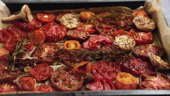 Various Kinds of Roasted Red and Yellow Tomatoes with Thyme and Garlic on an Metal Oven Tray