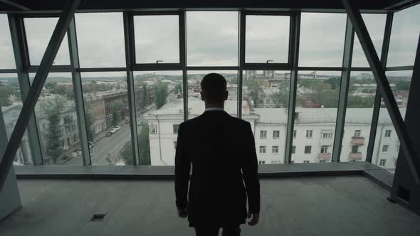 Man in Suit Look at Panoramic Window with Old Town View