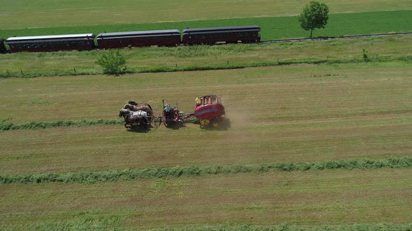 Aerial View of an Amish Farmer Harvesting His Crop with 4 Horses and Modern Equipment alt