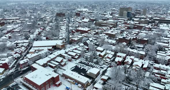 American city covered in fresh winter snow. Evening establishing shot of large town in USA. Snowy sc alt