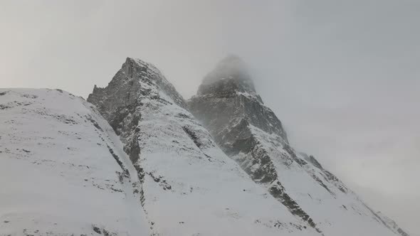 Aerial drone shot snow covered Otertinden mountain in Troms, Finnmark. Northern Norway.  Summit hid alt