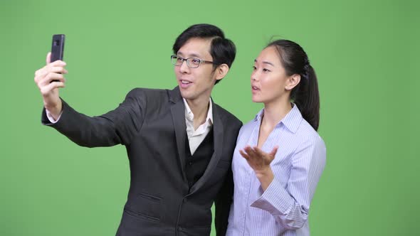 Young Asian Business Couple Showing Phone Together