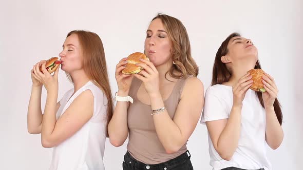 Three Girls Eating Delicious Burgers