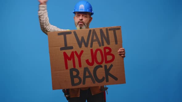 Senior Man Builder in Hardhat Holding Cardboard Placard Striking Against Blue Background