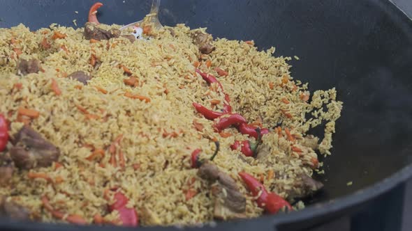 Big Vat with Cooked Pilaf or Rice Over an Open Fire. Street Food at the Party alt