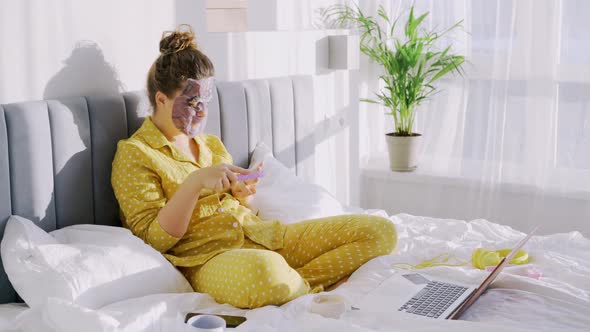 Woman in Funny Facial Masks Relax in Bed