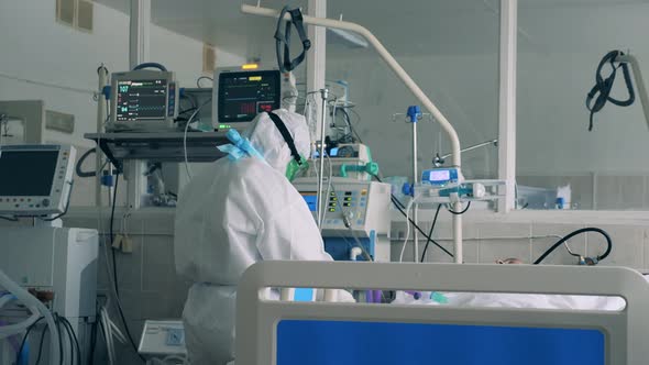 Doctor in Safety Wear Is Regulating Medical Equipment in a Covid19 Hospital Coronavirus Emergency alt
