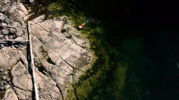 Man Swimming In  Fresh Lake Water Looking For Crabs. Crab Fishing In Egmont, Canada. aerial drone ap alt