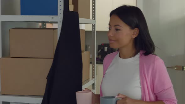 African Woman Tailor Bring Coffee to Colleague at Workshop alt