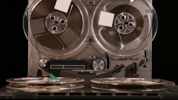 Two Reel to Reel tape recorders playing music together with four tapes alt