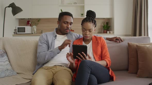 Young African American Family are Browsing the Web on the Tablet Computer While Shopping Online alt