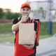 Outdoor Portrait of Delivery Man With Red Uniform Holding Food Bags Waiting for Customer - VideoHive Item for Sale