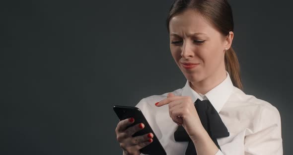 Vexed and Dissatisfied European Woman Swipes the Screen of Smartphone in a Rush Angry Office Worker alt