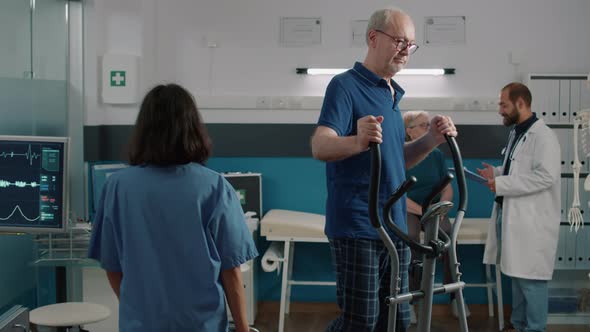Portrait of Senior Patient Using Stationary Bicycle for Recovery Program alt