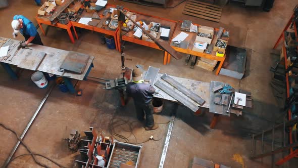 Plant for the Construction of Cranes - Men Working with Metal Plates alt