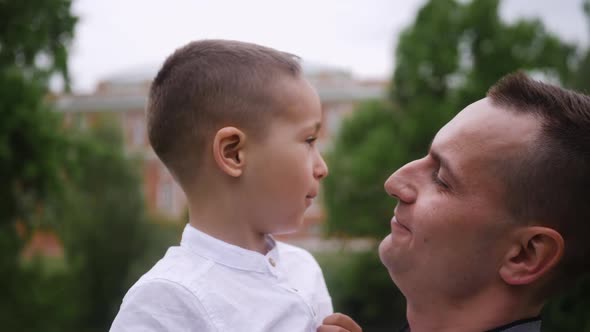 Beautiful Family Two Dad and Son are Stand on a Green Meadow in Summer alt