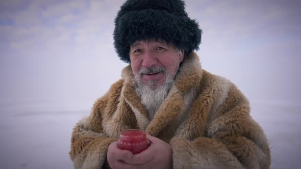 Medium Shot Portrait Confident Asian Indigenous Man Posing with Red Caviar Jar Outdoors alt