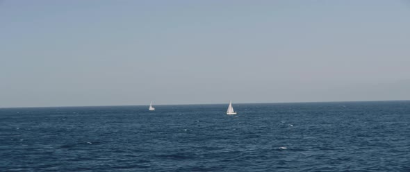 Ocean horizon view with two sail boat during a boat trip alt
