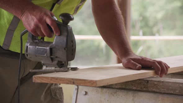 Closeup of construction worker using jigsaw