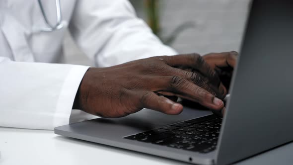Close Up African American Hands Typing Text on the Keyboard Laptop in Clinic alt