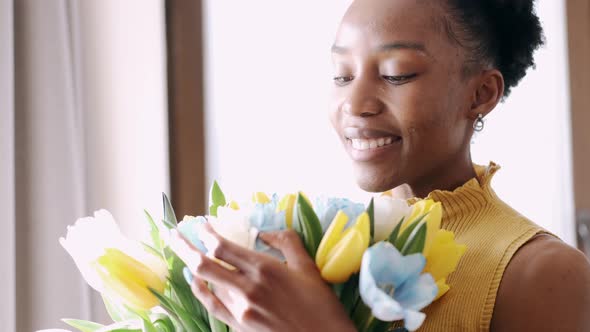 African American Woman Smiling and Looking at Tulips Bunch alt