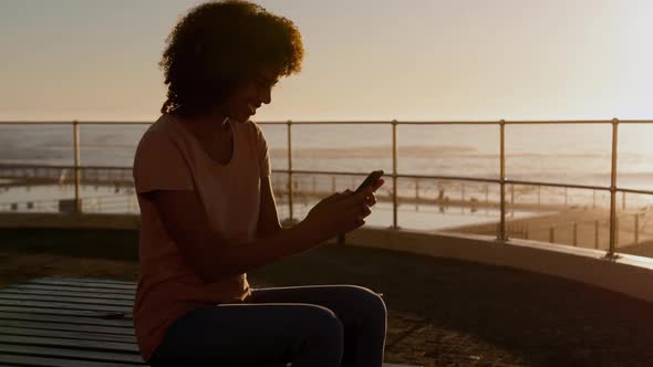 Woman using phone at sunset alt