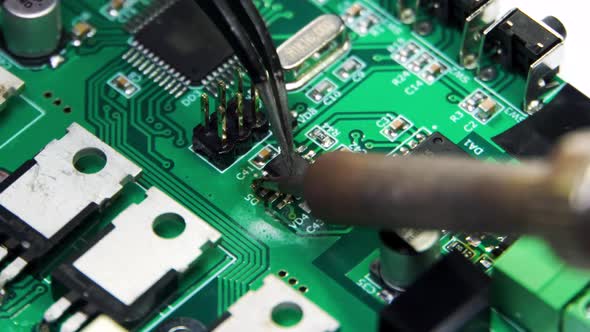 Technician Repairing Electronic of the Computer's Circuit Board By Soldering Irons Concept